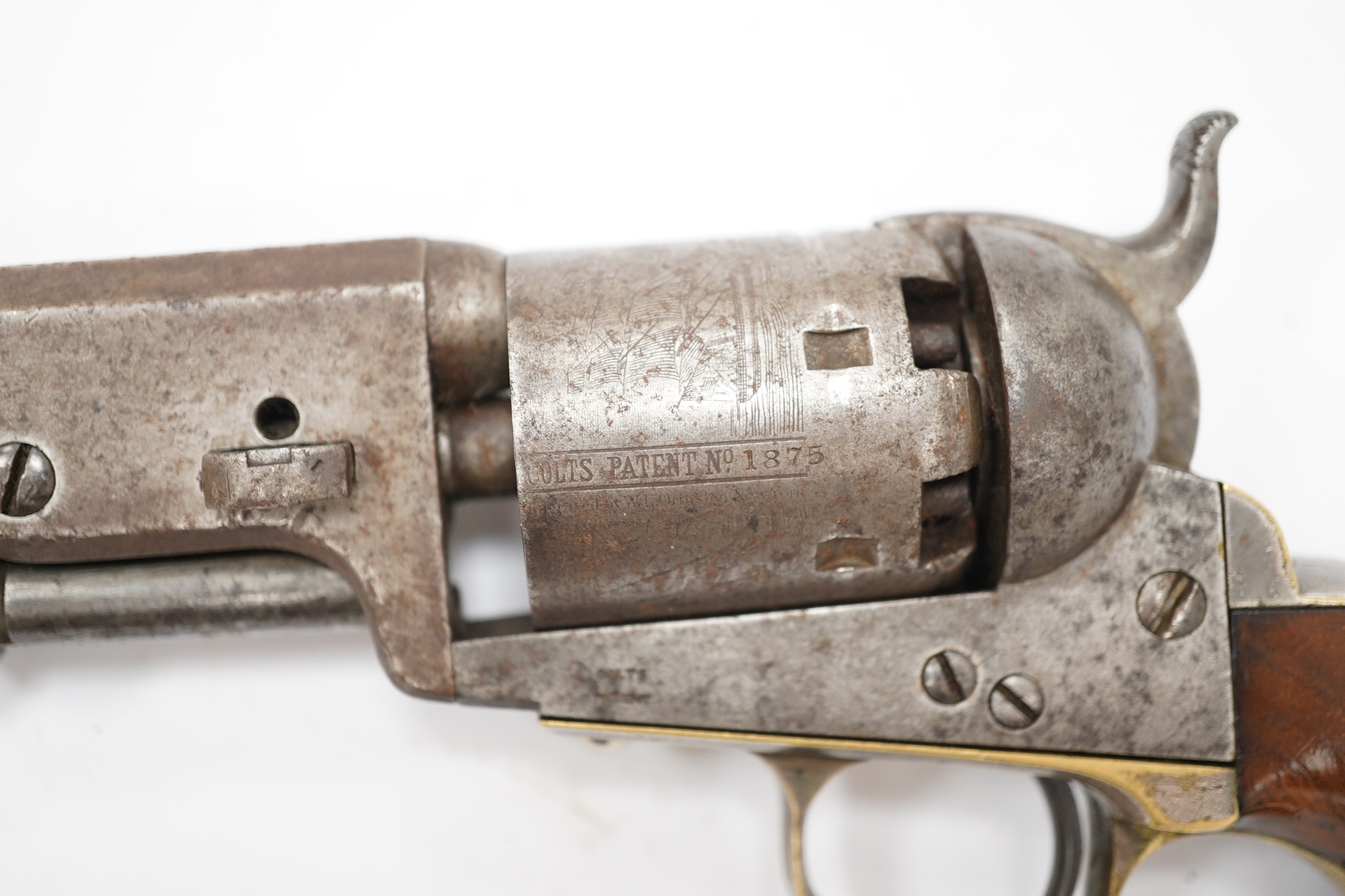 A six shot .36 Colt Navy single action percussion revolver, number 1875 (matching), regulation under lever rammer, signed barrel, roll engraved cylinder, brass mounts with traces of plating and single piece walnut grip,